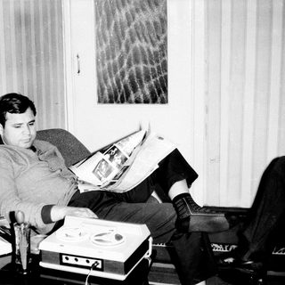 Man reading newspaper in relaxed indoor setting.