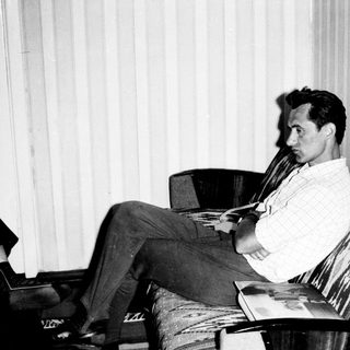 Man reading book in relaxed indoor setting.
