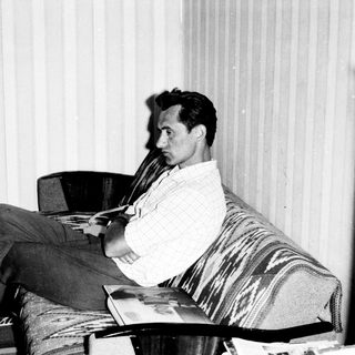 Man reading book in relaxed indoor setting.