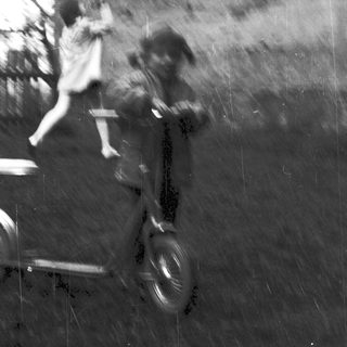 Blurred reflection of person riding scooter.