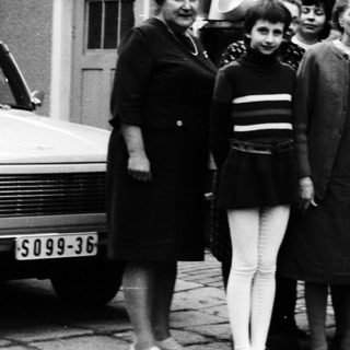 Group of people posing together outdoors in 1960s attire.