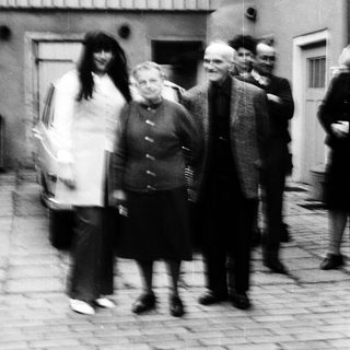 Group of people walking outdoors in courtyard.