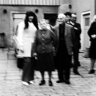 Group of people walking outdoors in courtyard.