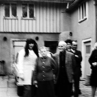 Group of people walking outdoors in courtyard.