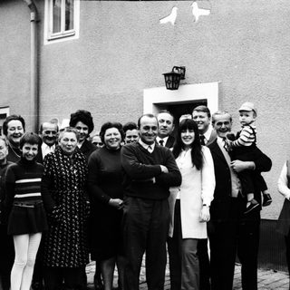 Family group photo outside residential building.