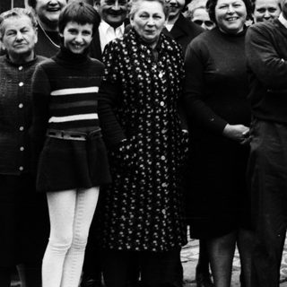 Family group photo outside residential building.