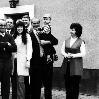 Family group photo outside residential building.