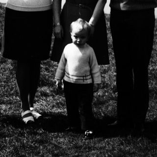 Family posing outdoors near a lake.