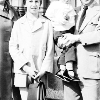 Family posing outside historic palace façade.