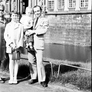 Family posing outside historic palace façade.
