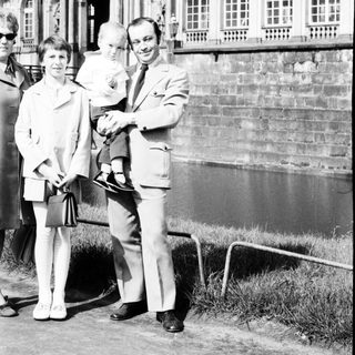 Family posing outside historic palace façade.