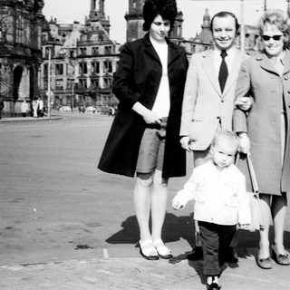 Family group photo in front of historic cityscape.