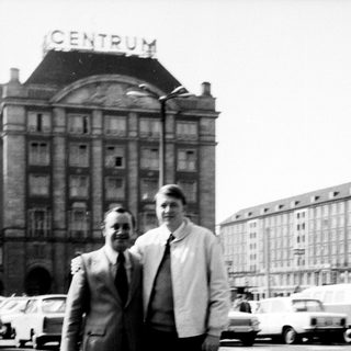 Two men posing in front of a building labeled "Centrum."