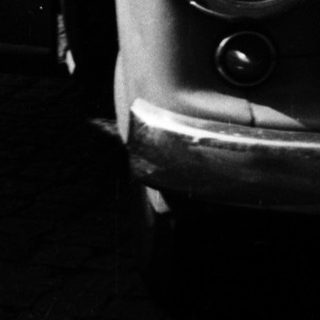 Classic car with open door in urban street scene.