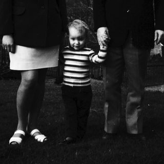 Family portrait with mother, father, and child outdoors.