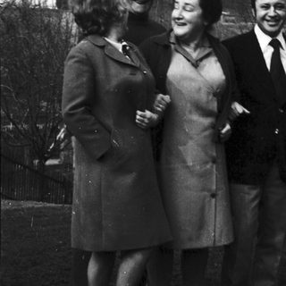 Five people posing outdoors in 1960s-style clothing.
