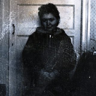 Person standing in doorway with snow-covered coat.