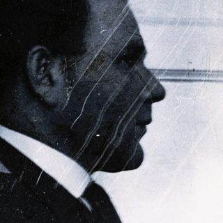 Silhouette of man in suit against frosted glass.