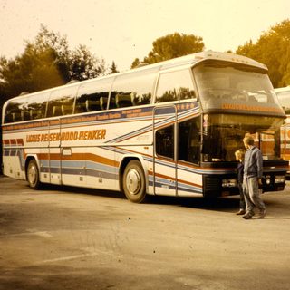 Two tour buses with passengers boarding.