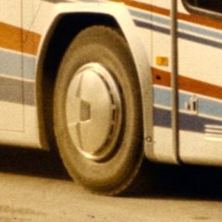 Two tour buses with passengers boarding.