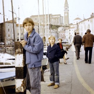Children walking along a historic waterfront promenade.