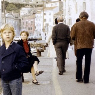 Children walking along a historic waterfront promenade.