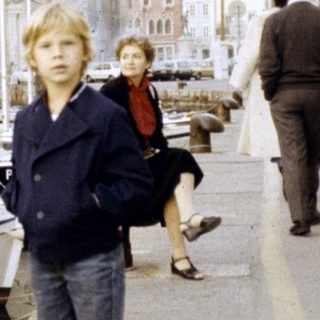 Children walking along a historic waterfront promenade.