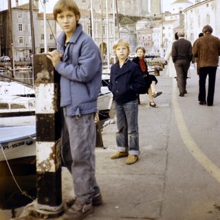 Children walking along a historic waterfront promenade.