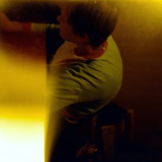 Person sitting alone in dimly lit room.