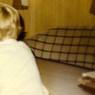 Office setting with woman typing, two children working at desk.