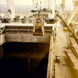 Industrial ship deck with cargo hold hatch.