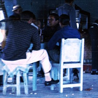 Busy bar interior with patrons and bartenders.