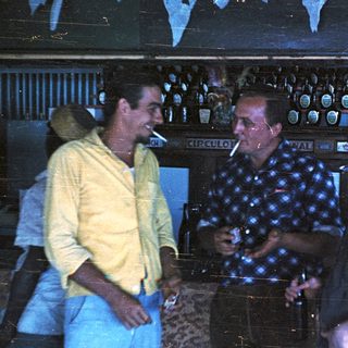 Three men in a dimly lit bar.