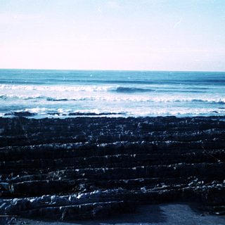 Coastal rocks with crashing ocean waves.