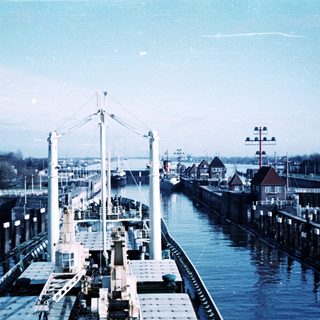 Historic port with docked ships and industrial waterway.
