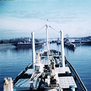 Ferry docked at port with waterfront structures.