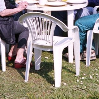 Four people eating outdoors with a dog.