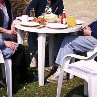 Four people enjoying outdoor meal together.