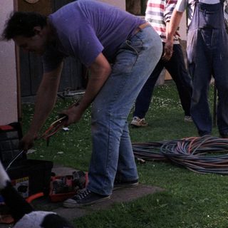 People connecting a camper to utilities.
