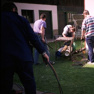People washing camper van exterior with hoses.