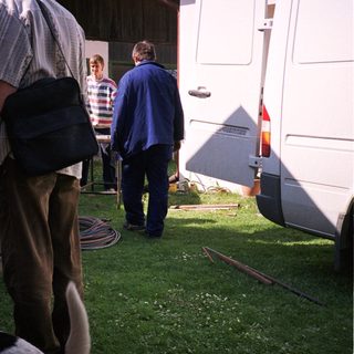 People preparing camping setup near RV.