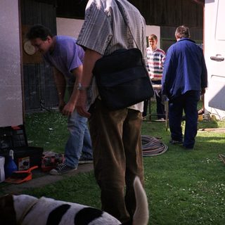 People preparing camping setup near RV.