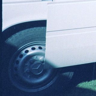 Three men standing by an open van.