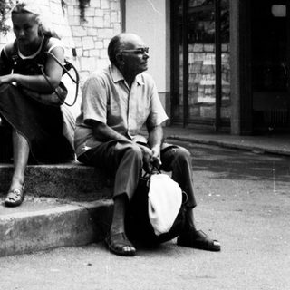 Family sitting on steps outside residential building.
