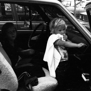 Child eating inside moving vehicle with adult.