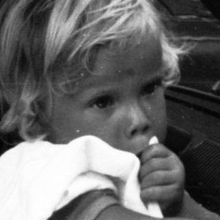 Child eating inside moving vehicle with adult.