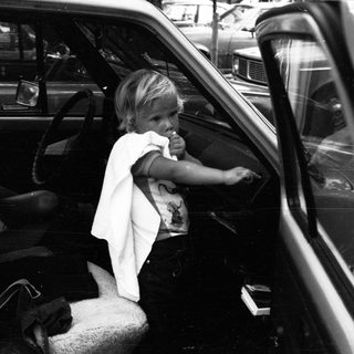 Child eating inside moving vehicle with adult.