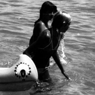 People enjoying floating and swimming in shallow ocean water.