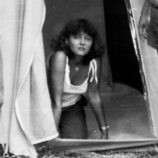 Family camping in tent at outdoor site.