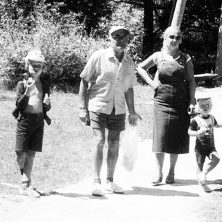 Family walking outdoors near a water tower.